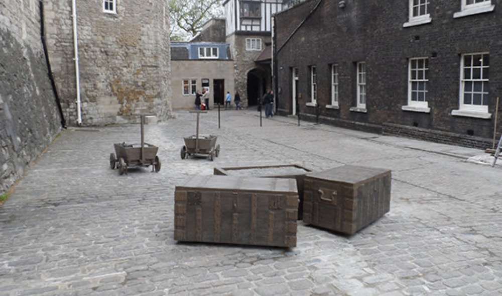 Moulded steamer trunk benches and carts in a cobbled courtyard at the Tower of London