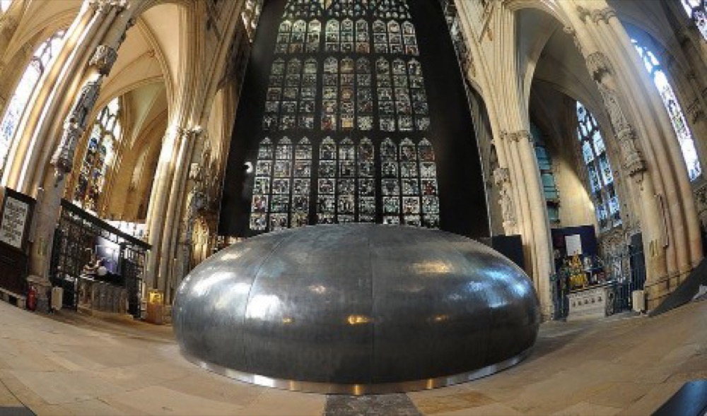 Large dark fibreglass orb installed in the nave of York Minster below the Great East Window